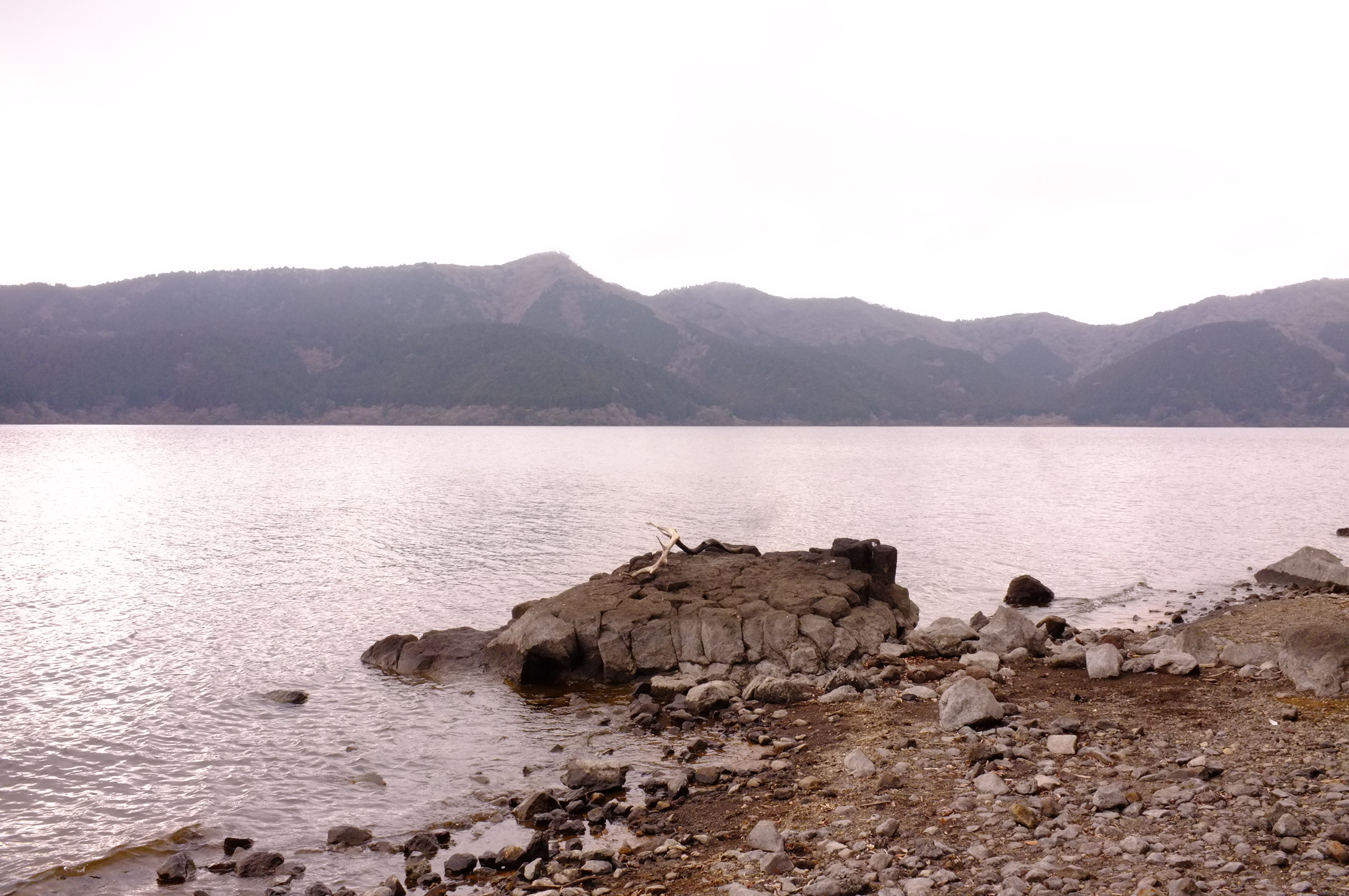 A rocky shoreline beside a mountain lake